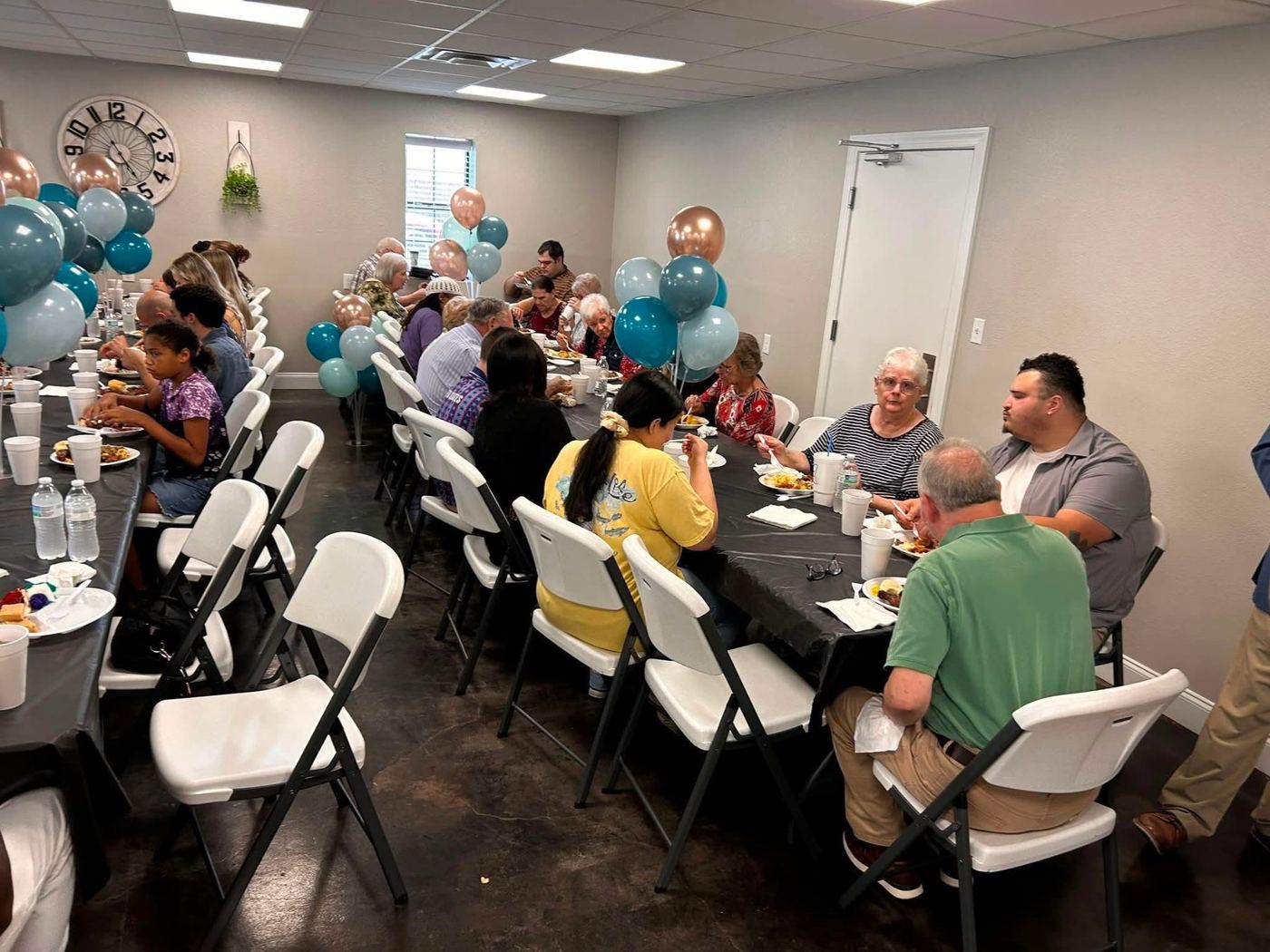 Members gathered around tables at a church fellowship