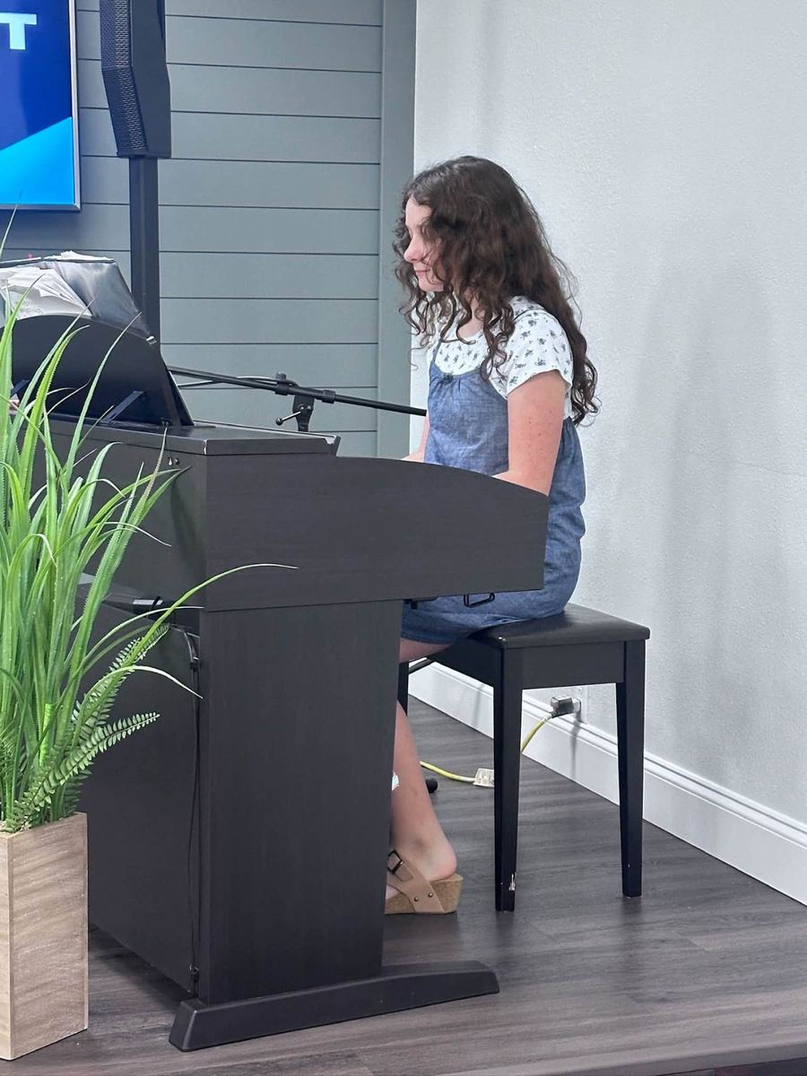 A young girl playing piano during the service
